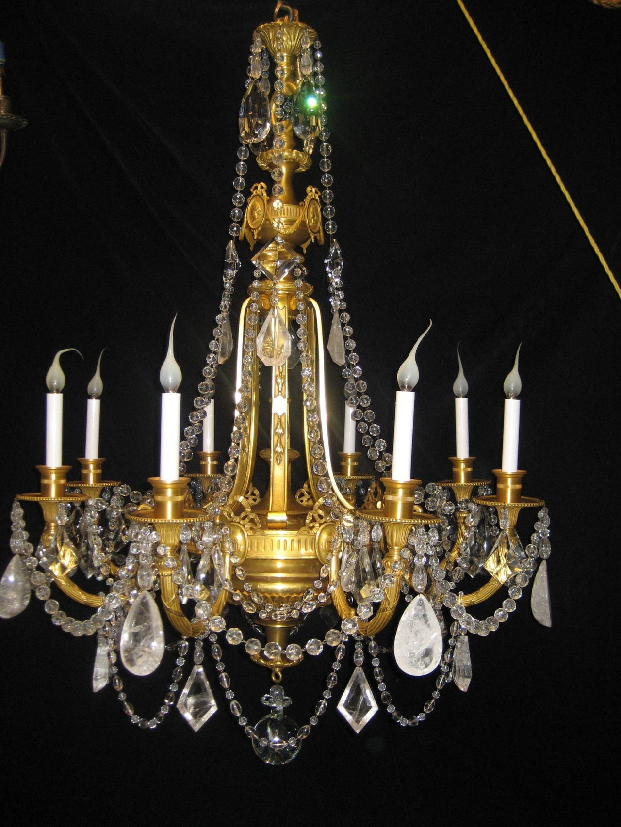 A pair of exquisite and large antique French Louis XVI style gilt bronze, cut rock crystal and crystal multi-light chandeliers of fine detail embellished with rock crystal prisms, crystal prisms and further adorned with crystal chains.