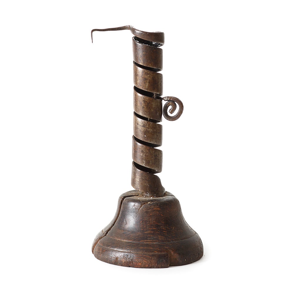 18th century Swedish wrought iron spiral twist candle holder on wooden base with a adjustable metal socket that holds the candle.