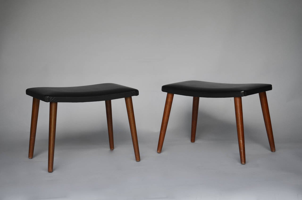 A couple of stools with legs of stained beech, upholstered with black imitation leather. 

We ship this item worldwide, please write to contact@apetersen.dk for shipping options and prices.