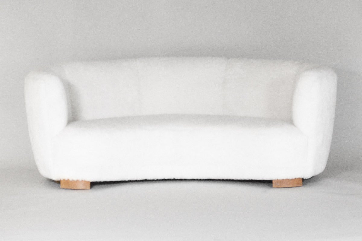 Banana formed sofa upholstered with short white lamb fur. Manufactured at Slagelse Møbelværk around 1930s. The sofa is newly refurbished with a very nice and carefully upholstered fur.

We ship this item world wide, please write to