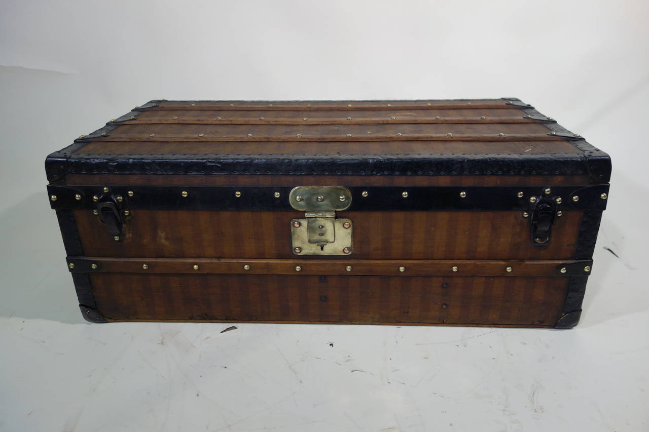 Louis Vuitton stripped trunk.

Brass lock.

Metal handle marked LV.
New inside.

circa 1870.

Size 92 cm of long X 32 high X 51 deep.

Deco: Front of a bed to store blankets, low table with a glass in decoration in a bedroom or living