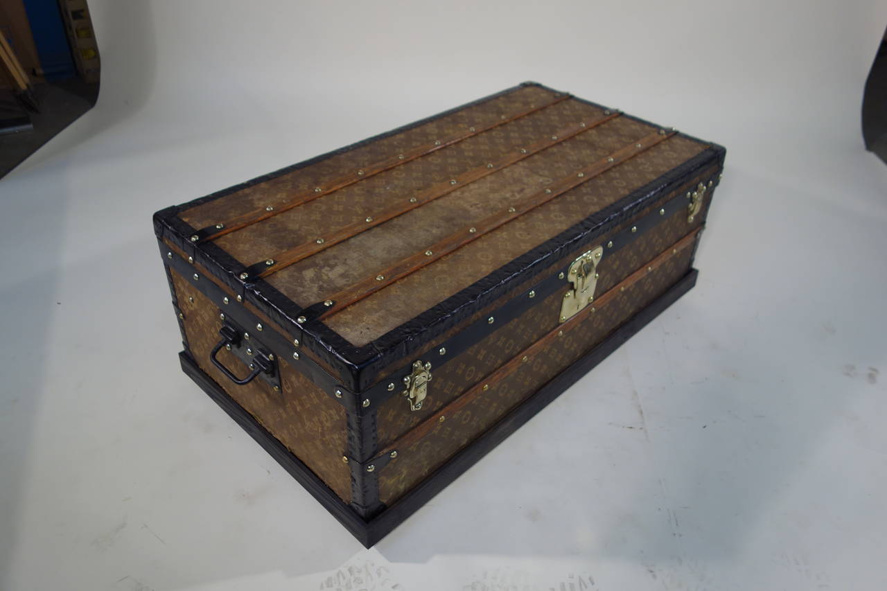 Cabin trunk canvas woven Monogram from Louis Vuitton. 
Solid brass jewelry marked Louis Vuitton.
Interior entirely renovated with original labels.
Dimensions in cm: 100 cm long x 31 cm high x 53 cm deep.

Available wood base visible on the