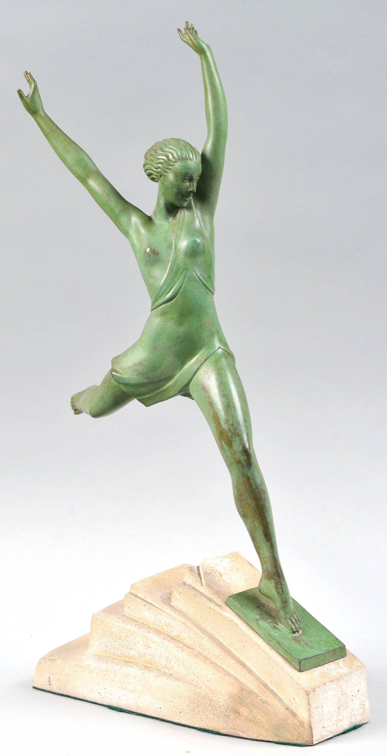 Pierre Le Faguays pseud. Fayral (French, Nantes 1892-1962).
Olympie or Atalante.
Green patinated bronze sculpture of an athlete, wearing a chiton unfastened at one shoulder in the manner of Diana the Huntress or an Amazon.
She spreading her arms
