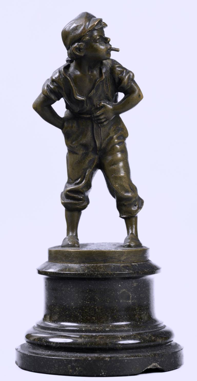 A French bronze figure of Gavroche - the emblematic character of the 1862 novel Les Misérables by Victor Hugo.
The street child is handling a cigarette in cheeky attitude.
Set on a round bronze base and a moulded black marble pedestal.
Signed in
