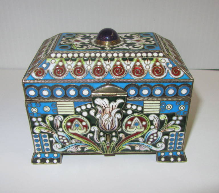 A Russian silver gilt and cloisonné enamel jewel casket.
Rectangular box with hinged trunk-shape lid set with an amethyst cabochon.
Hinged hasp.
Bearing the marks of Feodor Rückert (1840-1917) and not by the hand of the artist,
circa