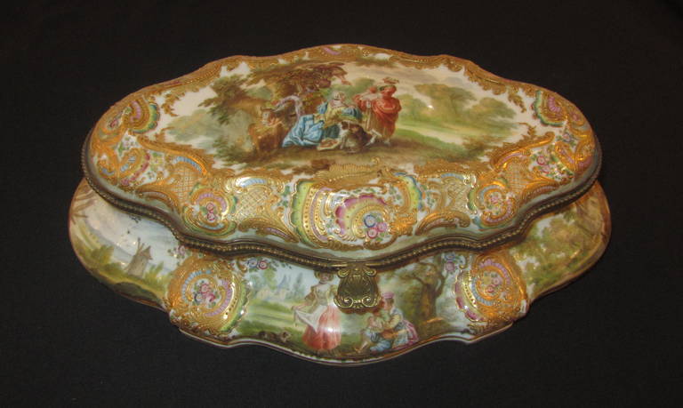 A 19th century Choisy-Le-Roy French sweetmeat dish with cover.
A gilt porcelain Bonbonniere of oval waved form.
The domed cover painted with mistletoe harvesting scene.
The sides with cartouches reserved with landscapes.
The underneath bears the