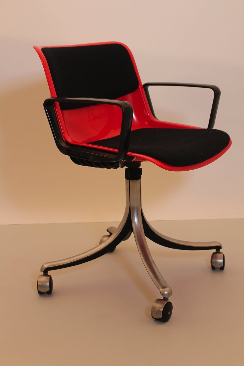 Red modernist swivelling desk chair by Osvaldo Borsani and produced by Tecno, Italy, 1970s.

Moulded red plastic seat with swivel function and upholstered with black fabric.
Aluminium base.
