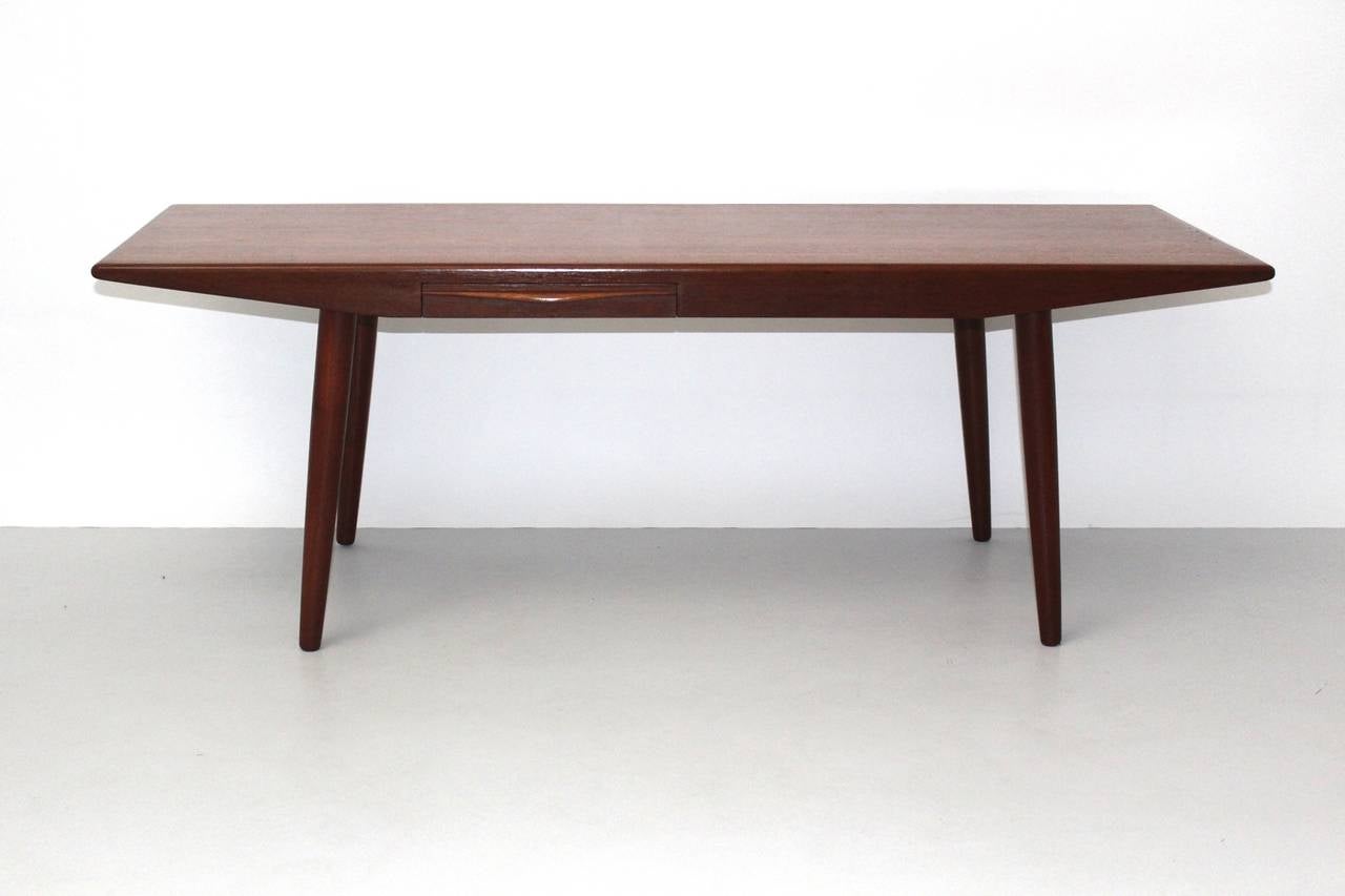 Scandinavian Modern vintage teakwood coffee table with two drawers and screwable legs.
The Scandinavian modern coffee table was designed by Johannes Andersen, 1960s, Denmark.
The coffee table appears very elegant and lightweight through its slightly