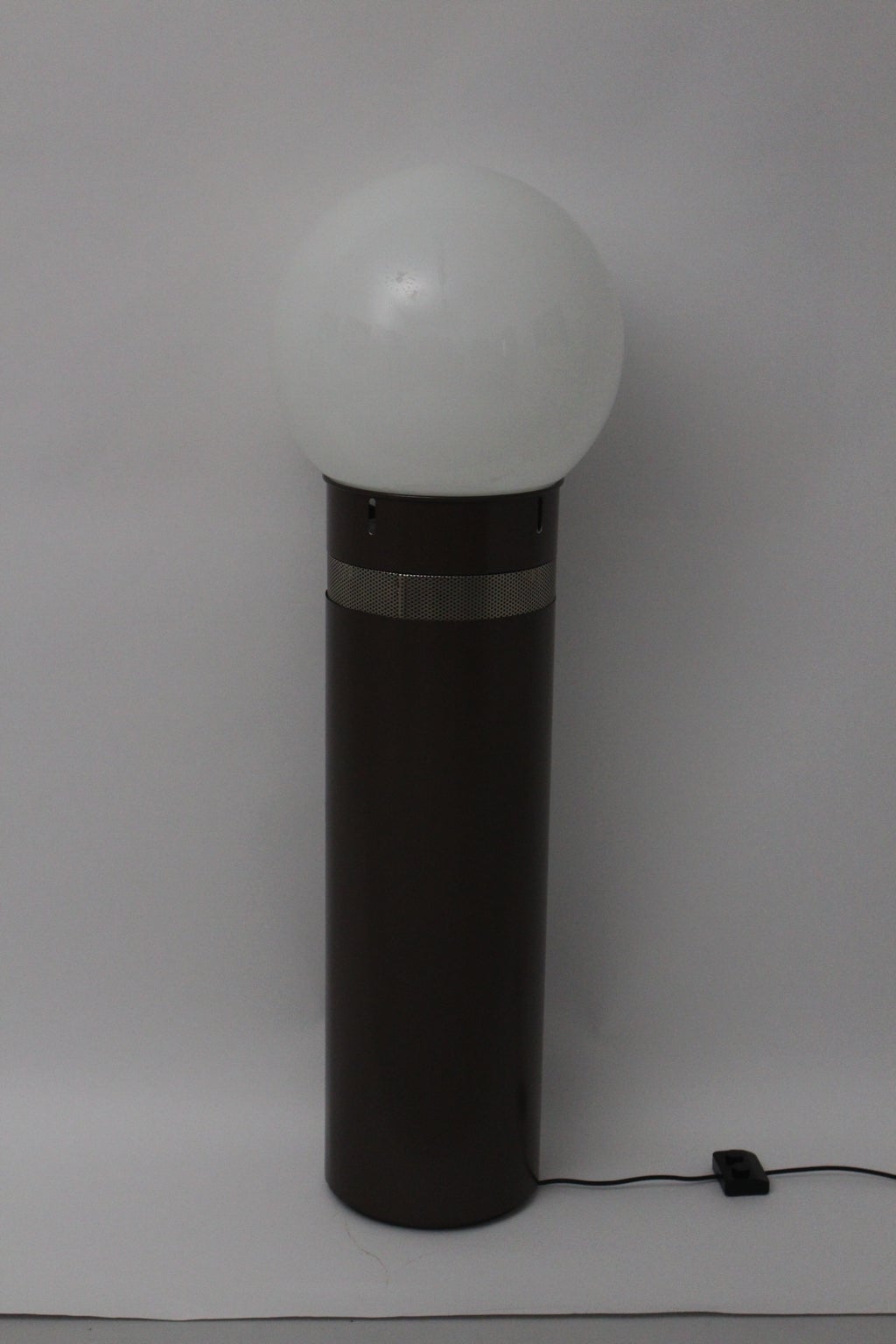 Floor light named Oracolo designed by Gae Aulenti and executed by Artemide, Pregnana Milanese, Italy.

A white glass sphere sits atop a cylindrical column of brown enameled metal.
The form is shaped like a bulb.

Three bulbs E27, two on/off