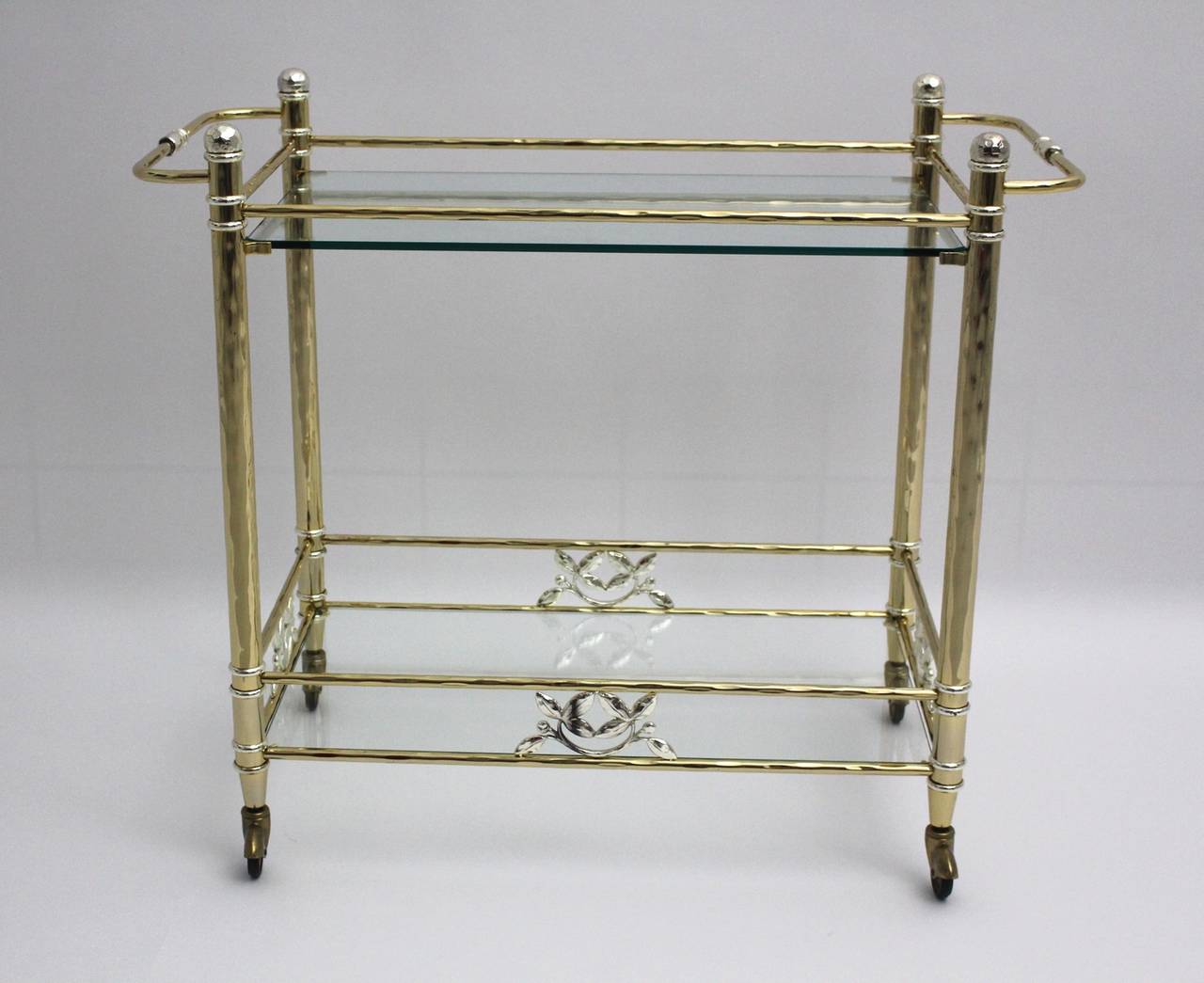 Golden-plated bar cart with silver plated flower elements. 

Two glass plates.