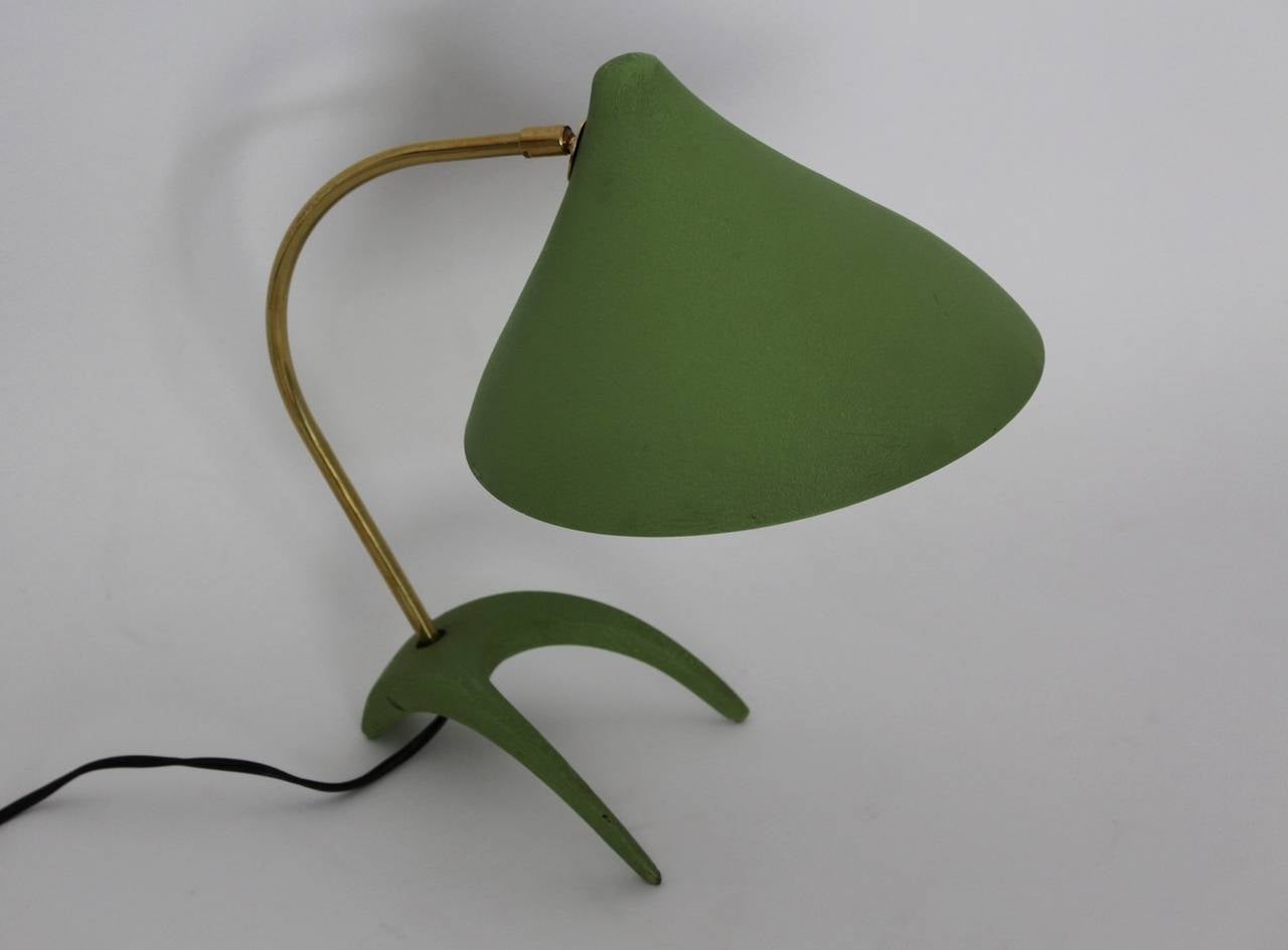 The table lamp was designed by Louis Kalff and executed by Philips, Netherland.

Cast iron foot, curved brass stem, conical aluminium shade.
Base and shade are original green lacquered and in very good vintage condition.
On and off switch, one