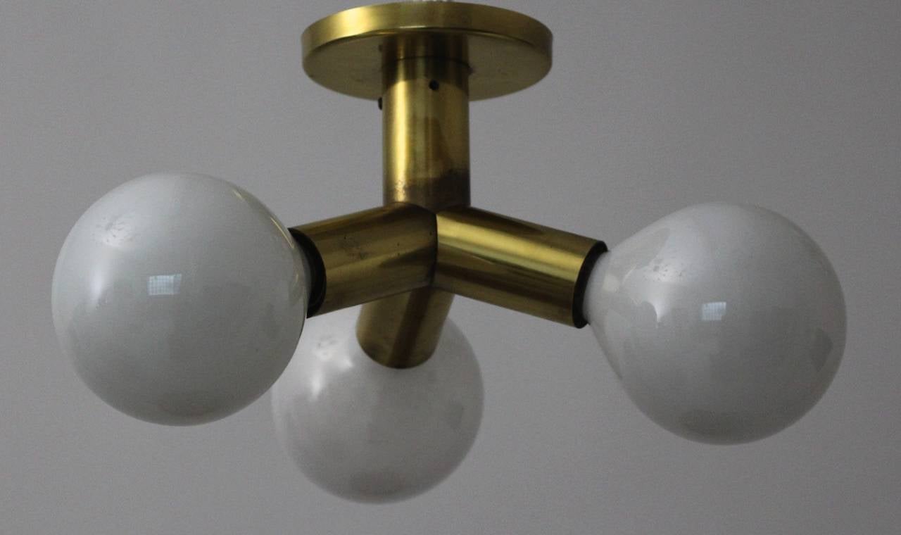 Space Age atomic brass chandelier designed and executed by J. T. Kalmar in Vienna, Austria.
The chandelier was launched in 1969.

This lighting has three brass tubes with three milk glass bulbs E 27. (max. 40W).
We offer shipping and packaging
