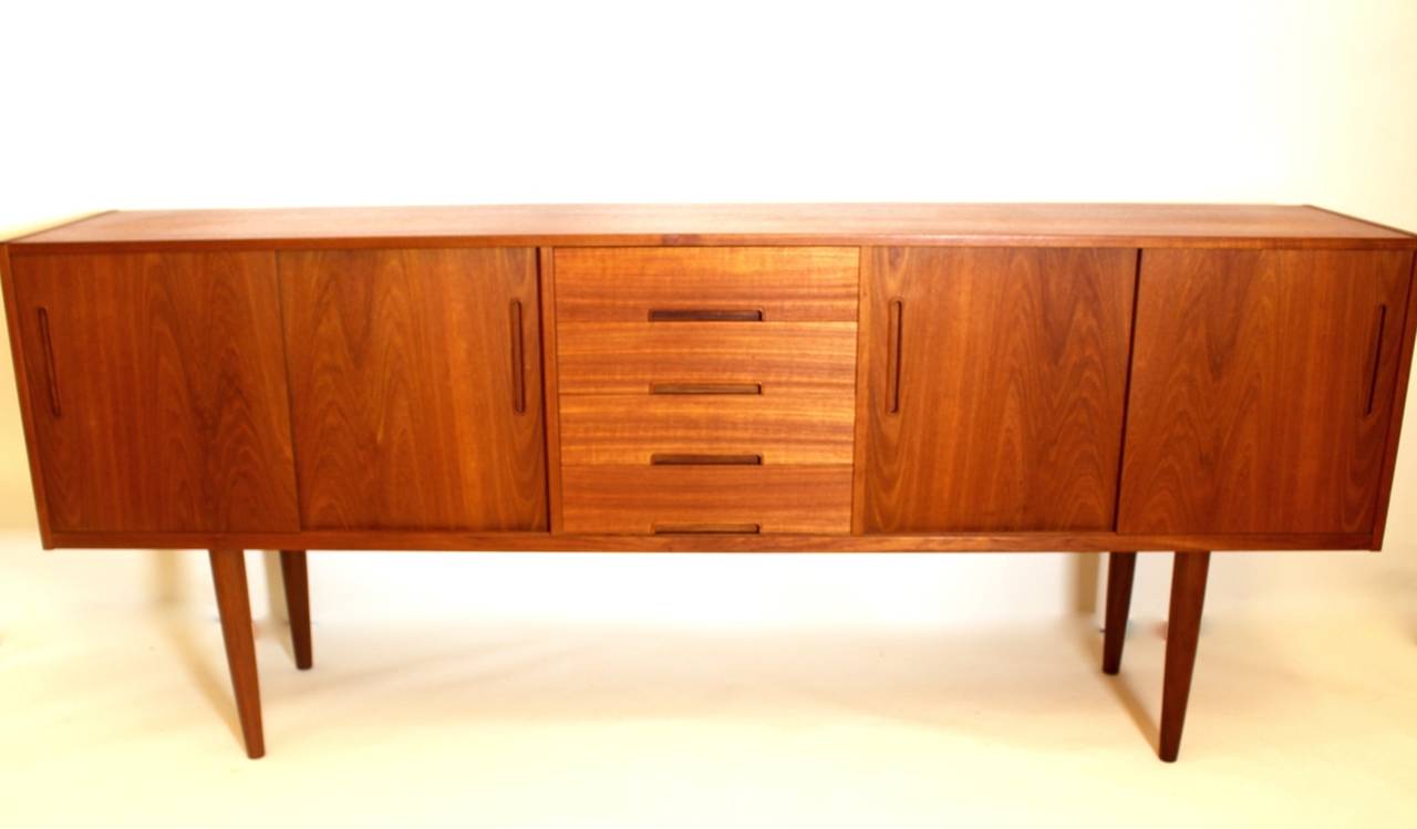 This presented credenza has a wonderful grain on the front side. 

This sideboard unites much storage and a wonderful timeless Scandinavian design.

The board has in the middle four drawers and on both sides there are compartments with sliding