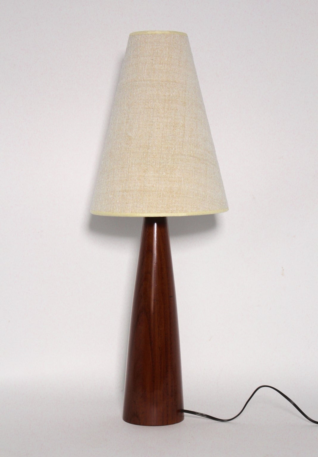 Scandinavian modern Cone shape teak table lamp designed and produced in Denmark, circa 1960.

Wonderful rich teak grain,shellac hand polished.
The recovered lamp shade shows natural linen. 

The height is including the shade. One socket E 14, on/off