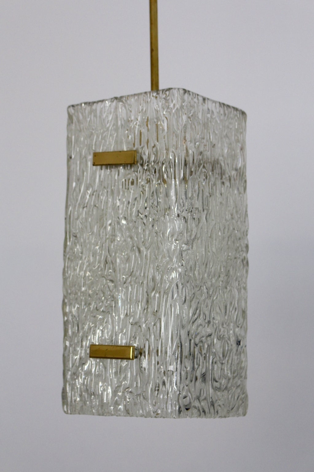 Mid Century Modern vintage clear glass pendant or chandelier, which shows two textured glass parts and held with four brass fittings.
One socket E 27

This presented pendant is a design piece by manufacturer and designer J. T. Kalmar in Vienna,