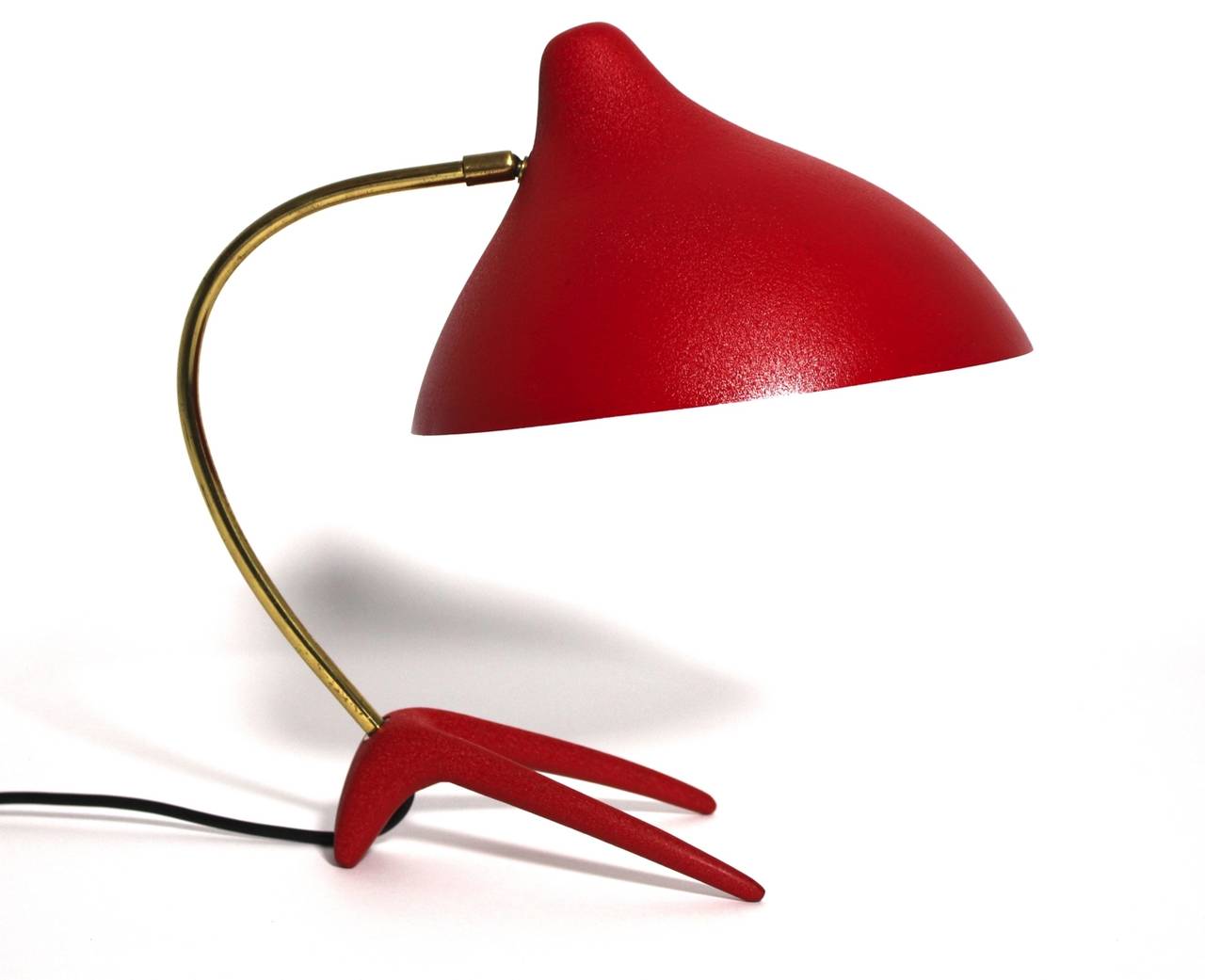Mid Century Modern tomato red lacquered metal table lamp, which features a cast iron foot,  a curved brass stem, a conical aluminium shade.  The table lamp is in very good original condition.
A design piece of Louis Kalff with the significant iron
