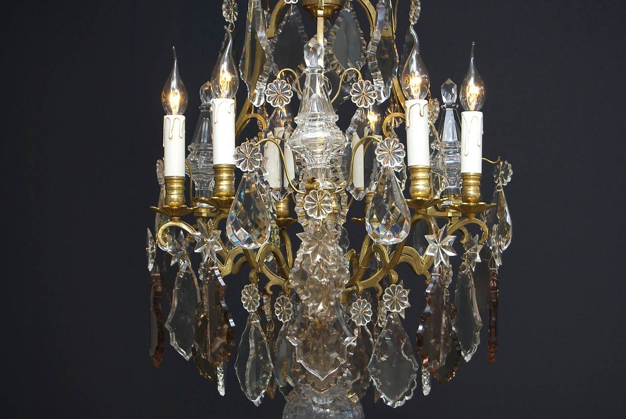 A wonderful six-light French chandelier in the style of Louis XV.
The chandelier has nine scrolled arms and three 'cage' arms. 
On the 'cage' arms there are crystal poignards.
In the centre is a decorative vase with a star with three arms and en