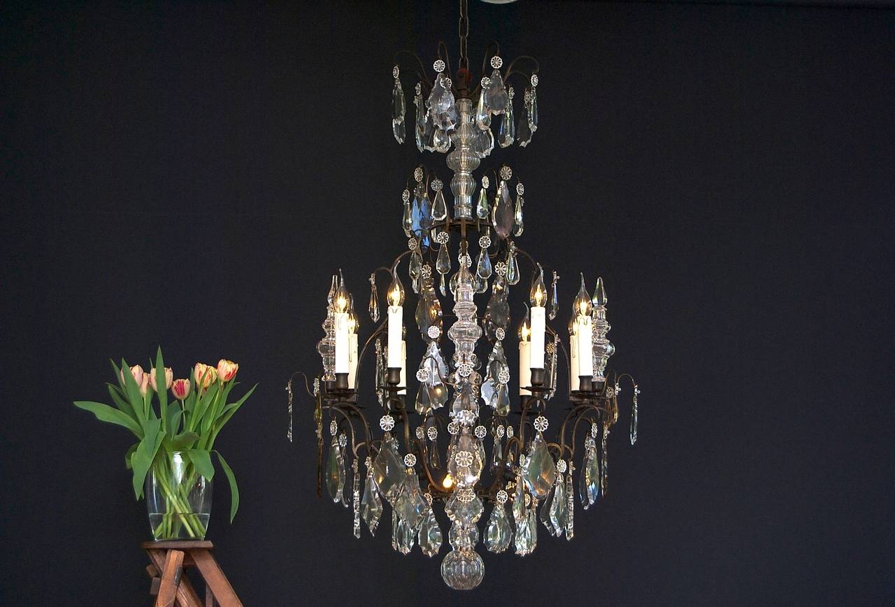 A fantastic and original French chandelier with twelve-light: eight-light around the chandelier and four-light in the centre.
'Cage' form; with eight scrolled candle arms and four main arms.
Bobeches (drip pans) in typical French floral shaped