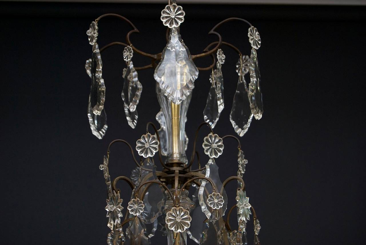 An excellent and original French chandelier with eight-light.
'Cage' form; with eight scrolled candle arms and three main arms.
The main arms are festooned with large crystal flower rosettes.
Bobeches (drip pans) in typical French floral shaped