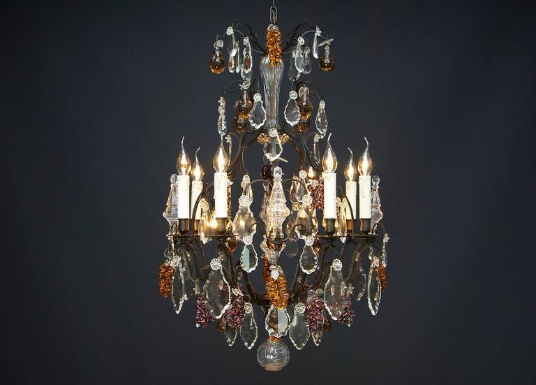 A very pretty and original French fruit chandelier with 12 light in Louis XV style.
With 8 scrolled candle arms with floral bobeches (drip pans) and 4 cage arms.
On the cage arms there are poignards and inside the arms there are four small