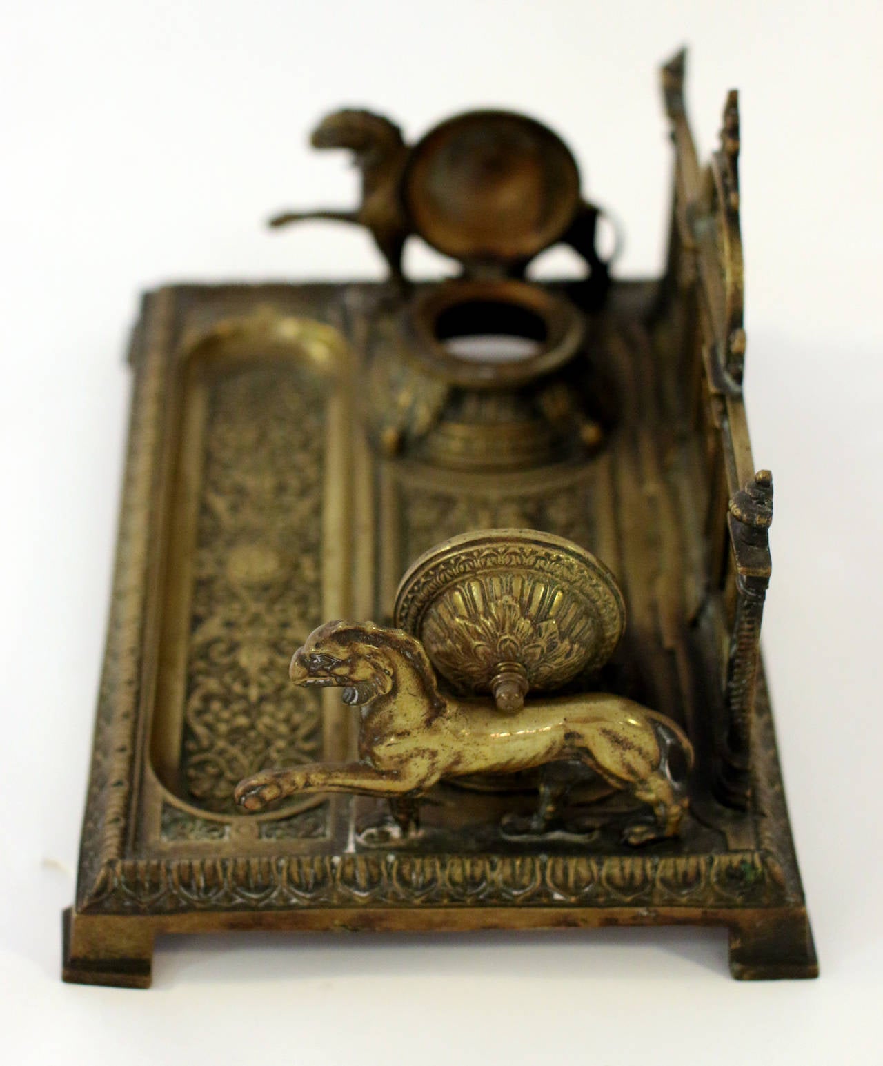 Very ornate and substantial 19th French bronze footed inkwell in the neoclassical style. Features include two lions on either side, Medusa's face between the two lidded wells, and a floral design on the pen tray. An arched center back with a laurel