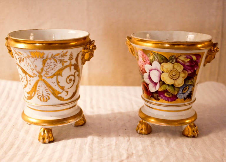 Unmarked pair of miniature Old Paris cachepots (or root pots). Each is painted in delicate floral vignettes featuring colorful primroses, morning glories, passion flower and roses. The backsides are painted with scrolls and applied molded classical