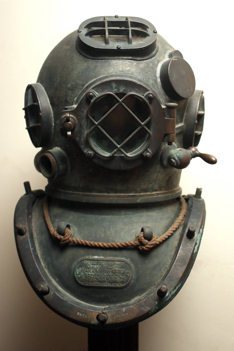 Vintage diving helmet manufactured by one of the oldest and most prestigious makers of early diving gear in the U.S. Mounted for display on a wooden base. Marked 