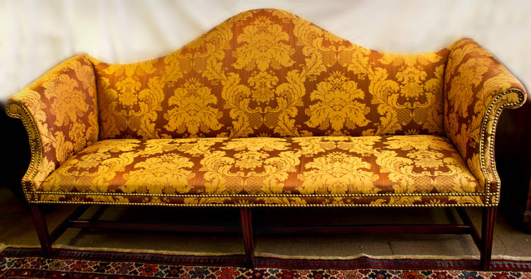 American Chippendale camelback 18th century sofa featuring a mahogany frame. It has newly upholstered by ex-Colonial Williamsburg master upholsterer in rich golden bronze silk damask Scalamandre fabric. The upholstery is highlighted with brass