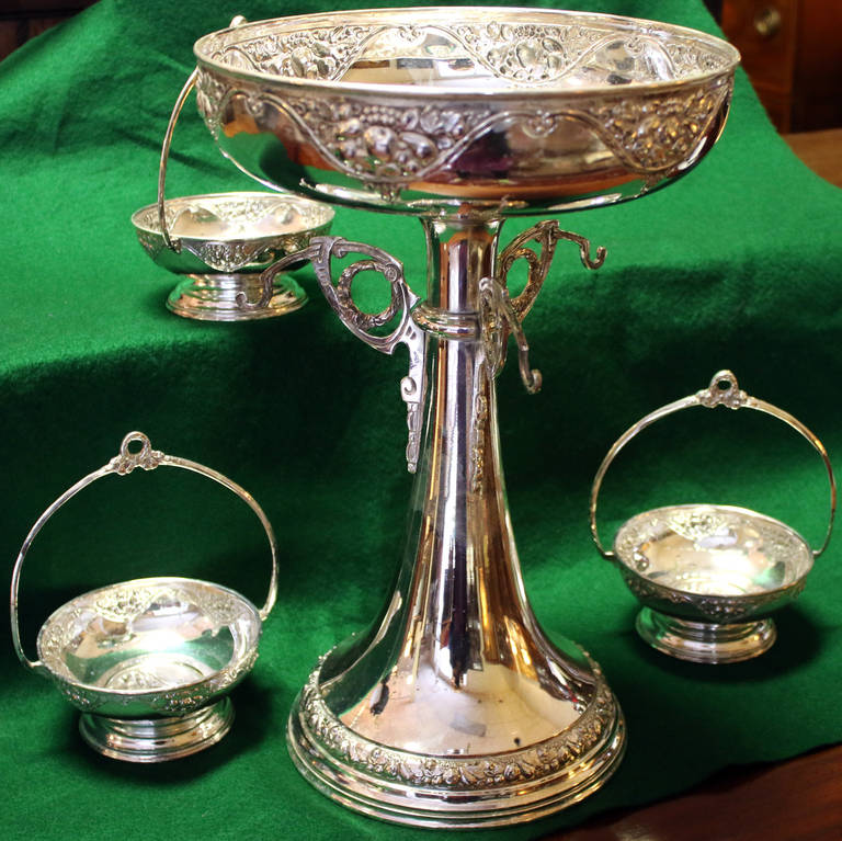 Silver plate three-arm Epergne featuring three small handled baskets with a fruit and wreath motif. It was made by 20th century artist Pedro Bignoli (marked with his name, a little symbol of a boat and 