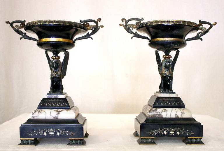 Pair of 19th century French Egyptian Revival compotes with etched squared bronze feet. The bases are also squared and are made up of five layers of beveled marble and onyx with incised details. Bronze winged sphinx figures support a graceful flaring