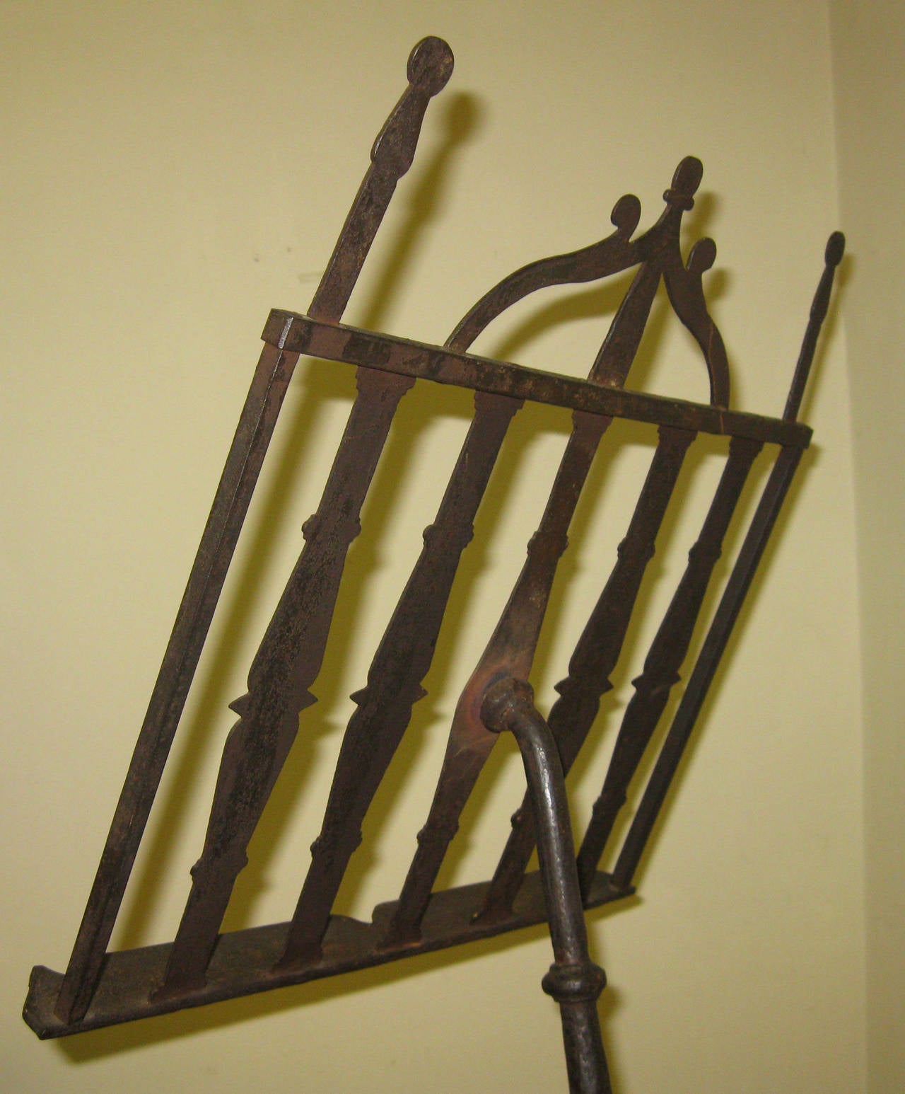 Hand forged metal antique music stand featuring an ornamental rack and tri-foot base. In a way it is primitive but there is an adjustment mechanism for the rack to go forward and back. This interesting historical piece could be used for sheet music