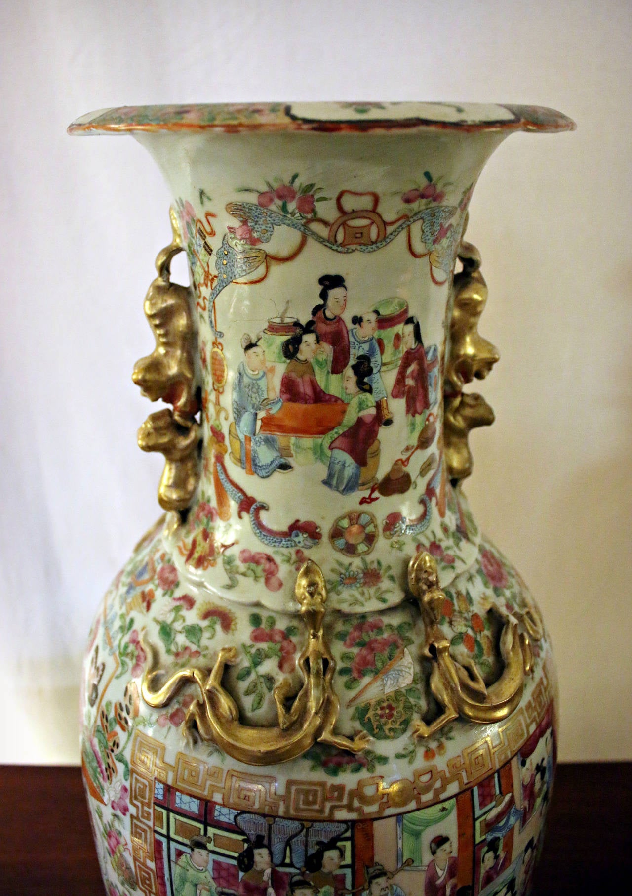 Outstanding matched pair of monumental sized Chinese export temple vases in the Mandarin pattern. Heavily decorated with scenes of colorful figures accented with flowers and insects. There are four gold dragons on the sides of each vase as well as