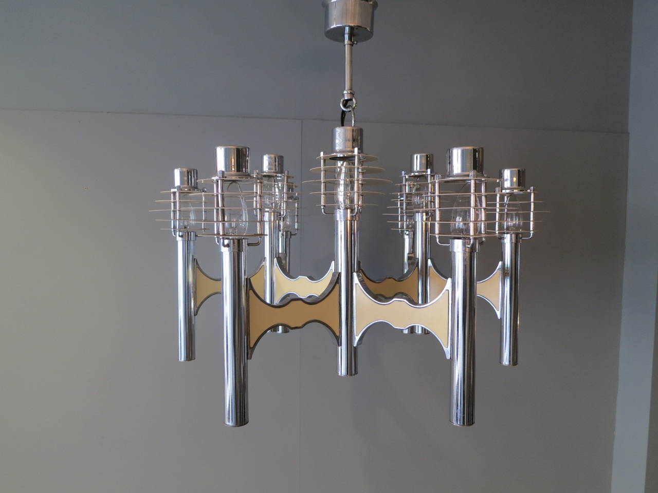 A large nine-arm modernist chandelier in chrome and ivory with original bulb diffusers. Designed by Sciolari.