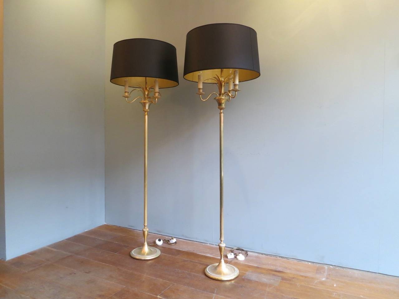 A pair of floor lamps in brass with bespoke made black shades with gold lining. Newly re wired. Very much in the manner of Maison Charles.