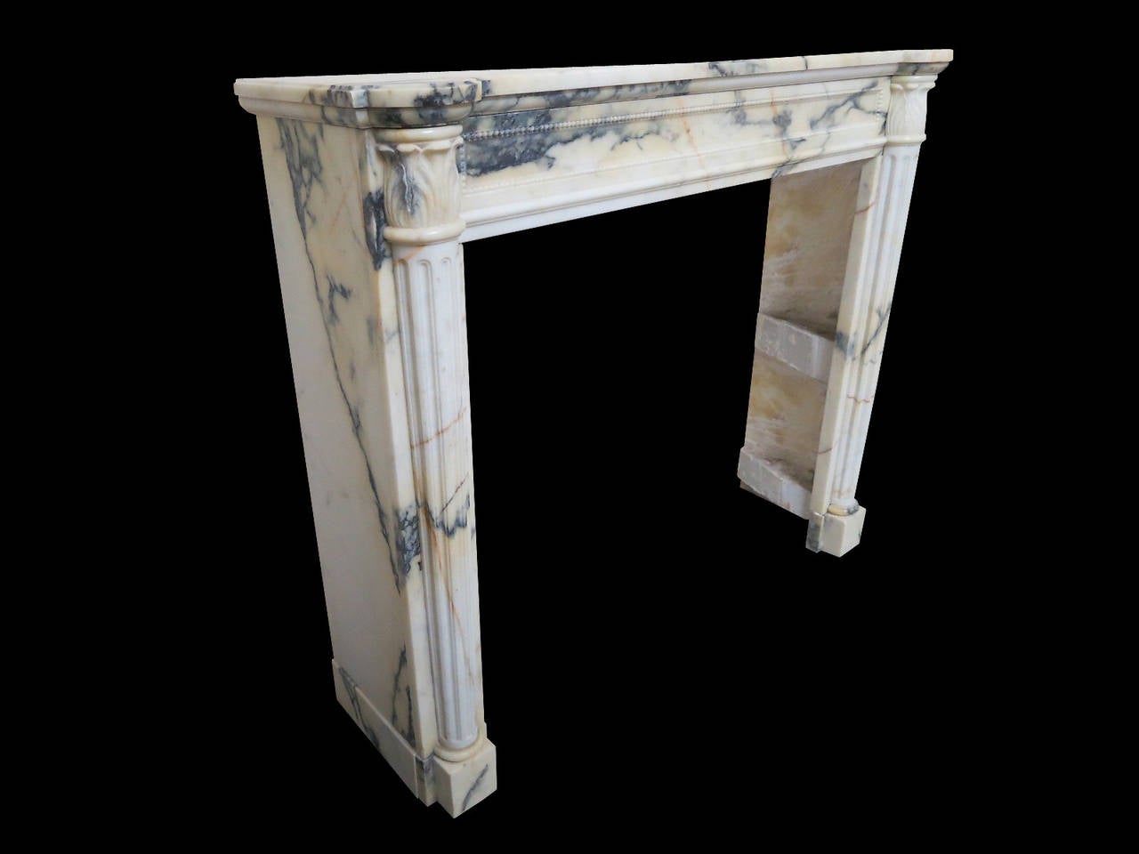 A fine quality 19th century French mantel in the Louis XVI manner, carved in rare and richly veined and colored Italian Panazeau marble. The jambs of tapering fluted columns surmounted by carved Acanthus leaf. The frieze with a fielded beaded panel