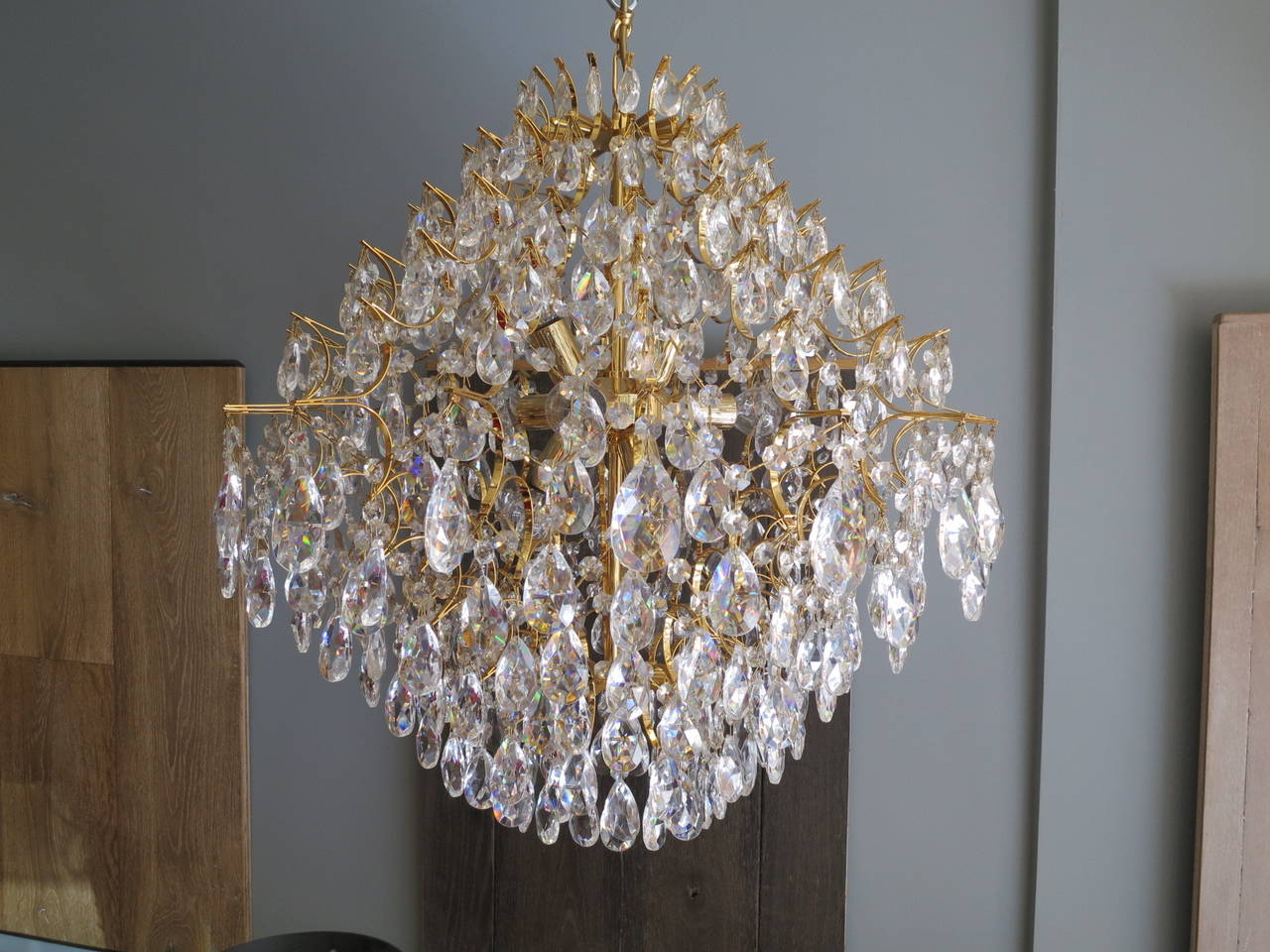 An unusual Italian crystal chandelier, with a contemporary designed gold lacquered frame, with traditional cut crystal drops. The light has nine-light fittings and dated from the 1970s.