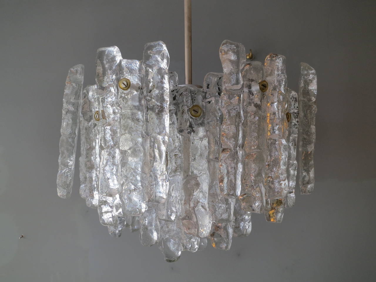 A pair of textured glass on silver and nickel frames chandeliers with nine light fittings by J. T. Kalmar, Austria.