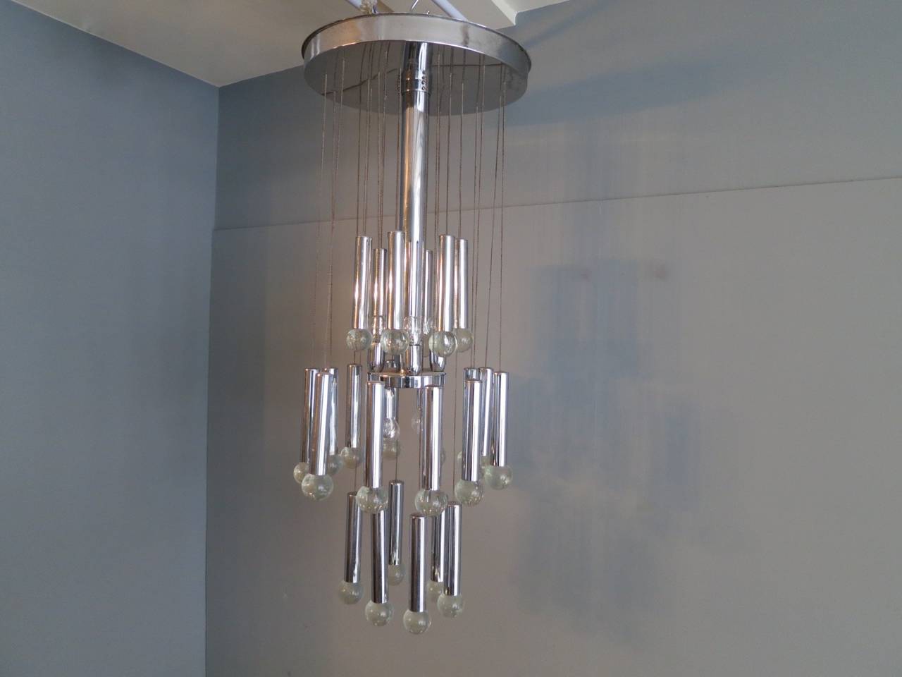 A chrome and glass pendant or chandelier by G. Sciolari, with three tiers of hanging chrome tubes with glass balls and eight lights fitting in the centre.