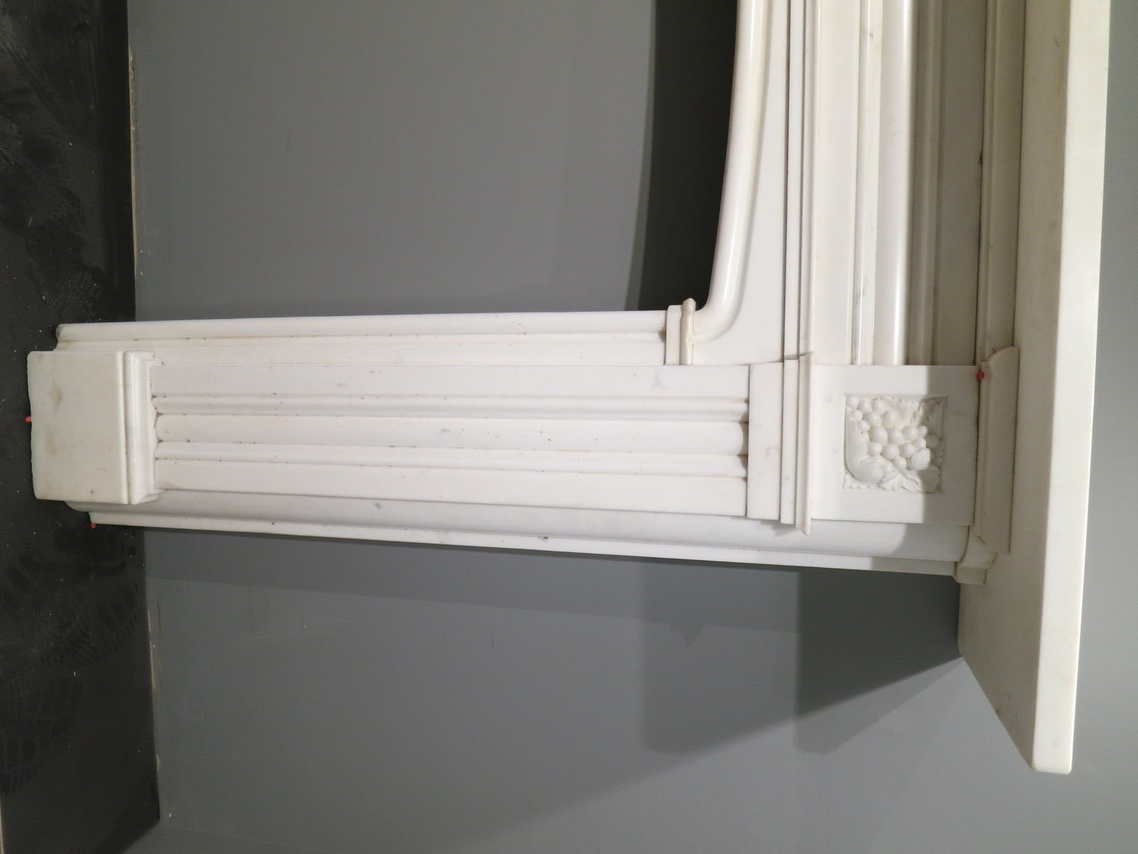 A large Regency period Italian statuary white marble fireplace surround. Having a generous mantel with matching shaped and molded panels to jambs and frieze. Cushion holding to outer jambs, with molded in grounds and a domed interior. The corner
