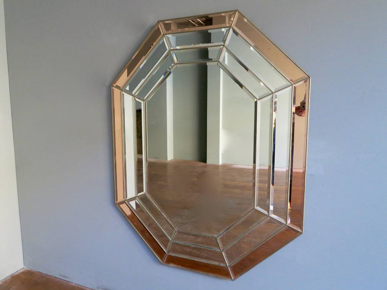 A large bevelled and paneled octagonal mirror with copper tinted outer border.