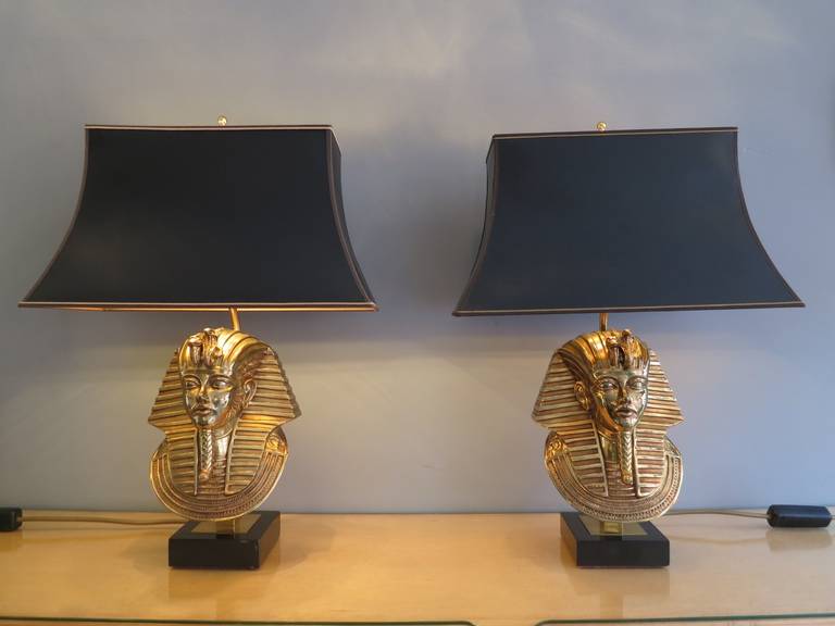 A pair of Egyptian revival Pharaoh head table lamps  in brass/bronze 24k gold plated on black marble base, with original shades.