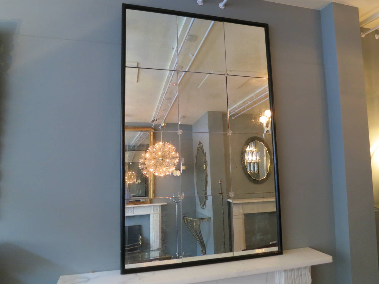 Large panelled mirror from Italy, the original glass lightly distressed with age within a black wooden frame. Can be hung portrait or landscape.