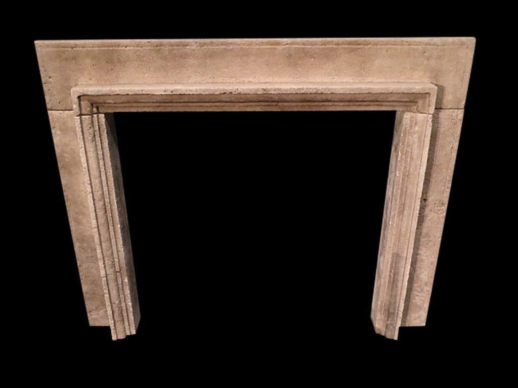 A large travertine stone fire surround with simple bolection style molding imported from Rome, 19th century.