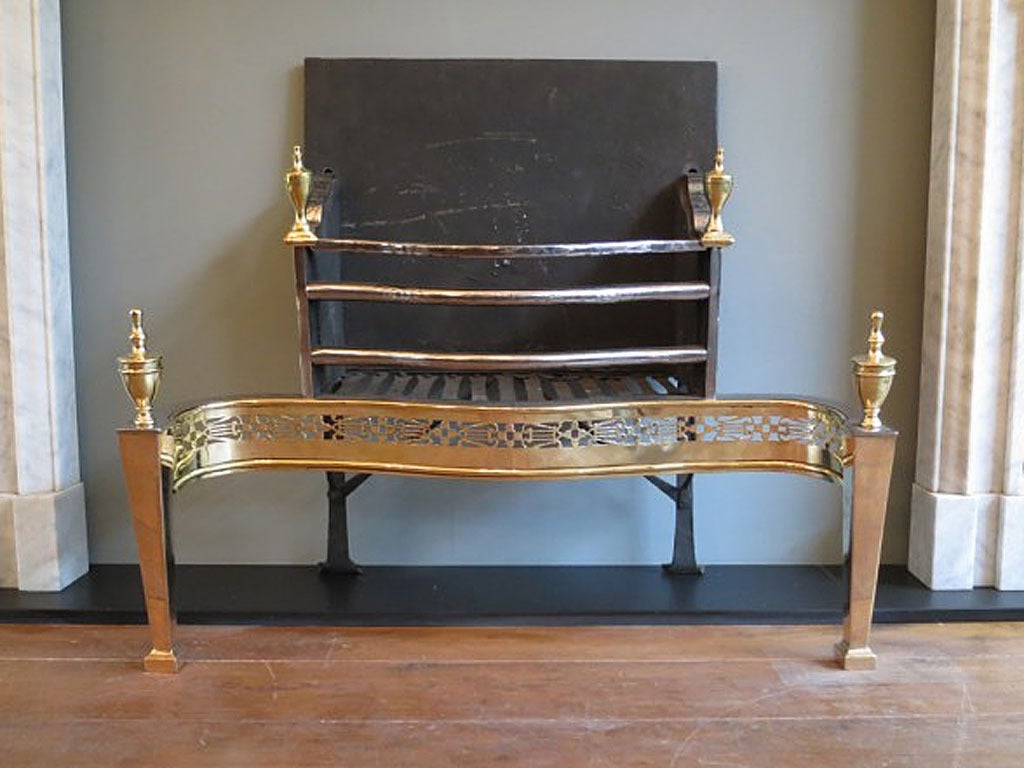 A large 19th century English polished steel, Gun metal and brass fire grate in the Georgian manner. Brass tapering legs surmounted by classical urn finials. Intricately pierced Gun Metal  fret work and bowed shaped bars again surmounted by brass
