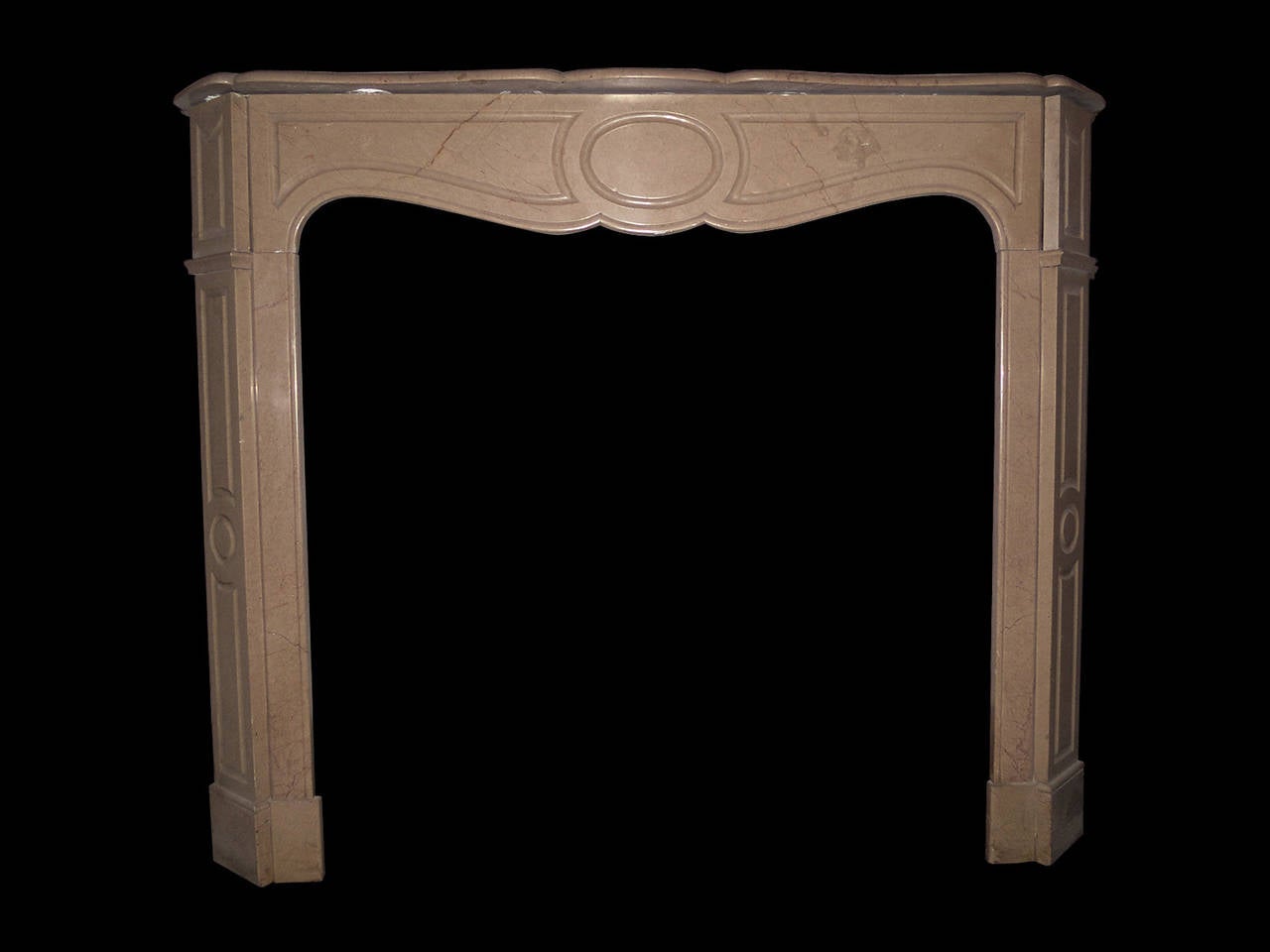 An antique French pompadour fireplace surround in a lightly veined creamy brown marble.