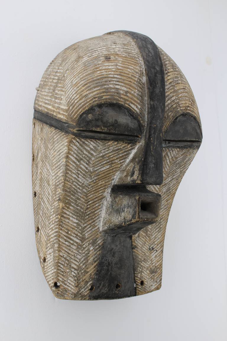 A early, or mid 20th century Congo tribal mask or 'kifwebe'. In the Songye language, a mask is a kifwebe: this term has been given to masks representing spirits and characterized by striations. Depending on the region, it may be dark with white