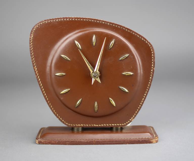 Desk clock designed by Jacques Adnet.
Manufactured in France around 1950.
All in leather with brass details.
In good original condition, with minor wear consistent with age and use, preserving a beautiful patina.

For competitive delivery