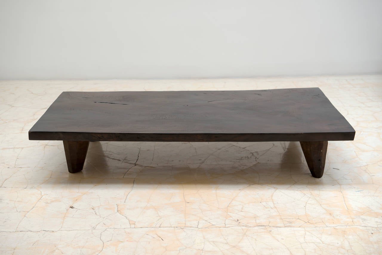 Solid piece of wood, carved out of one large piece, legs are not connected, but continuous. It is a Mid-Century piece, acquired and refinished by Chista.