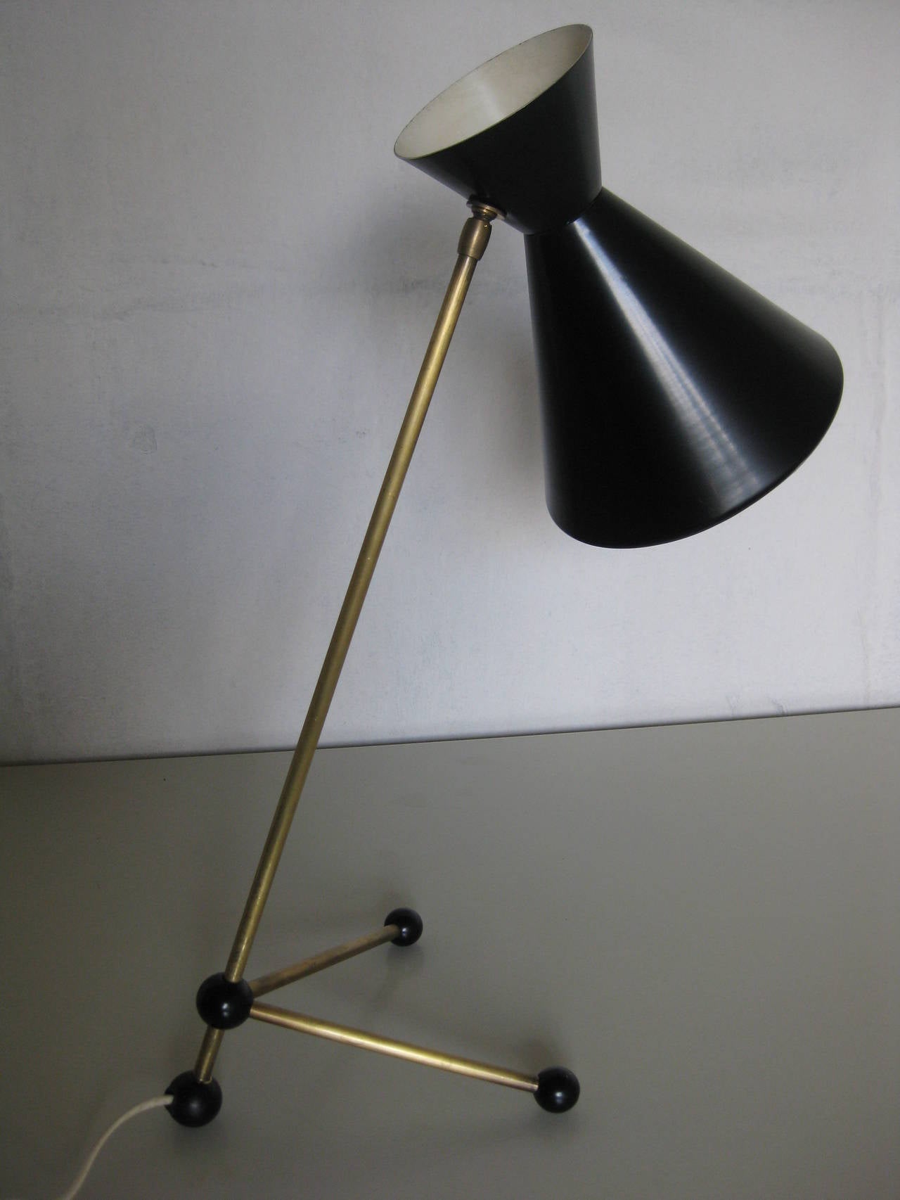Very nice 50ies table lamp probably designed by Otto Kolb 1951
Brass rod stem and legs with adjustable connector,enamble metal shade and messing feet