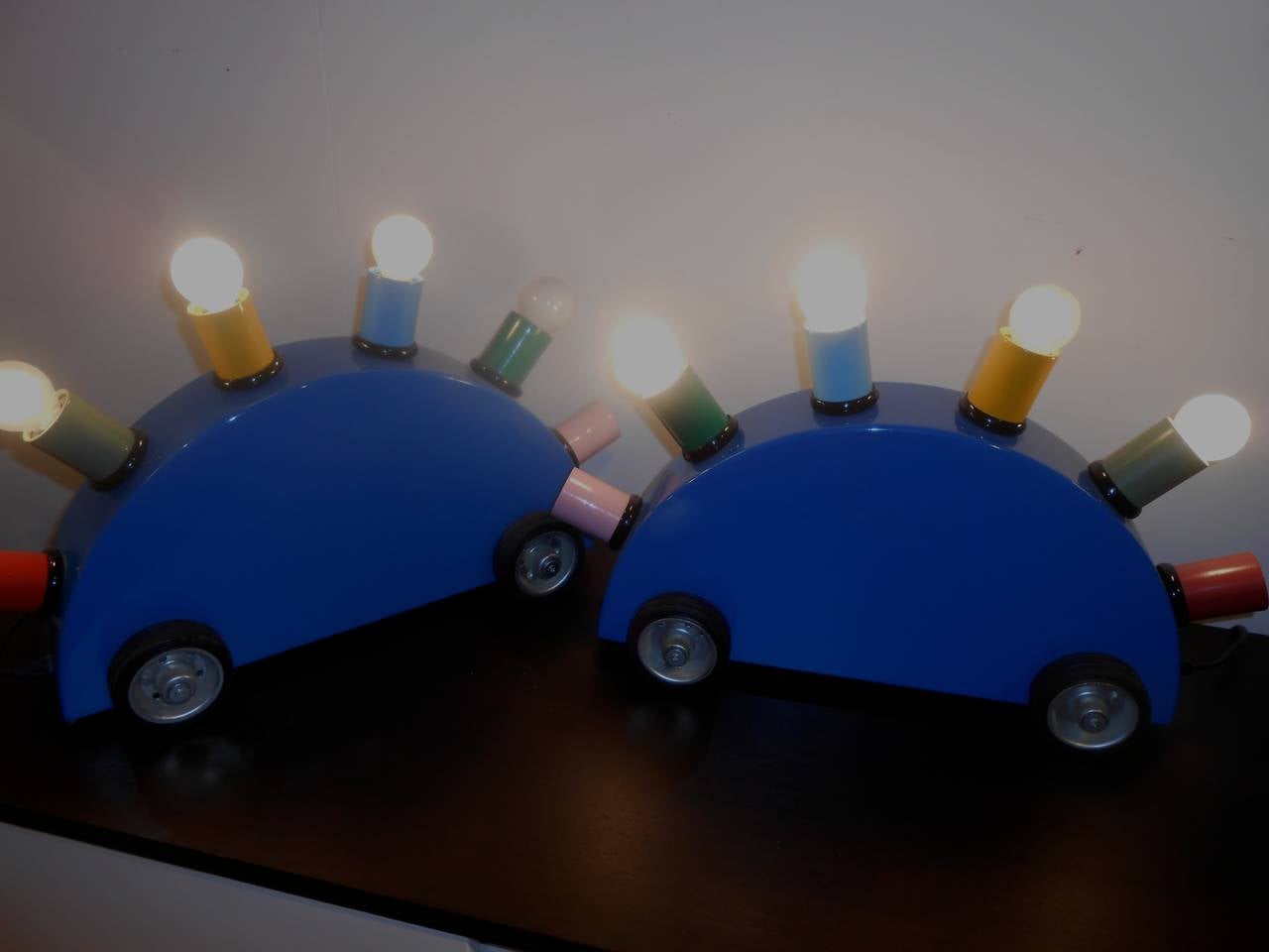 5 lights each.
Memphis  Milano metal tag under the base ( 1981 )
Rubber wheels.
Recently sold in London by Sotheby's, similar lamps were part of the David Bowie collection.